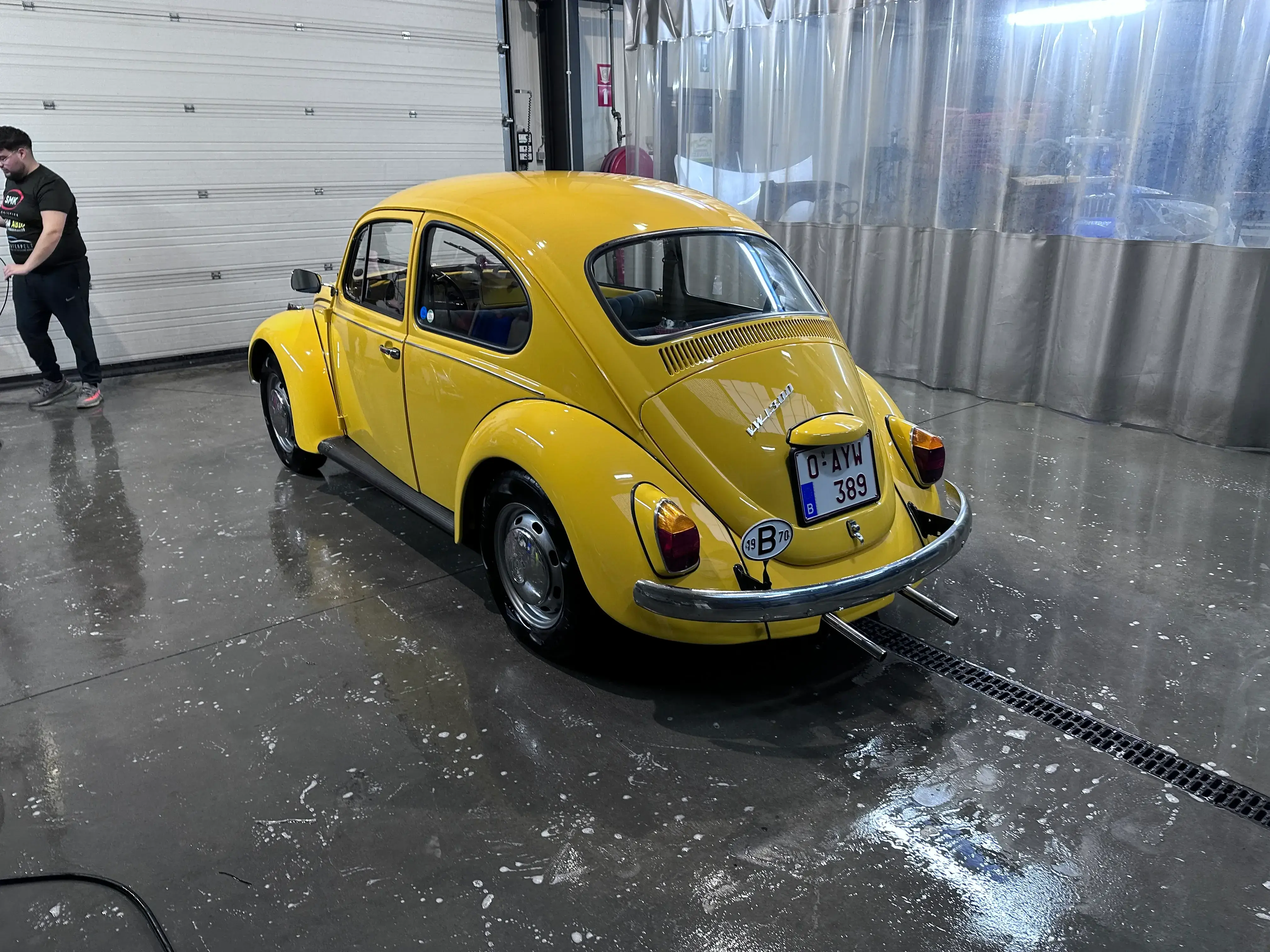 Professionele detailing van glanzende, gerestaureerde gele Volkswagen Kever oldtimer